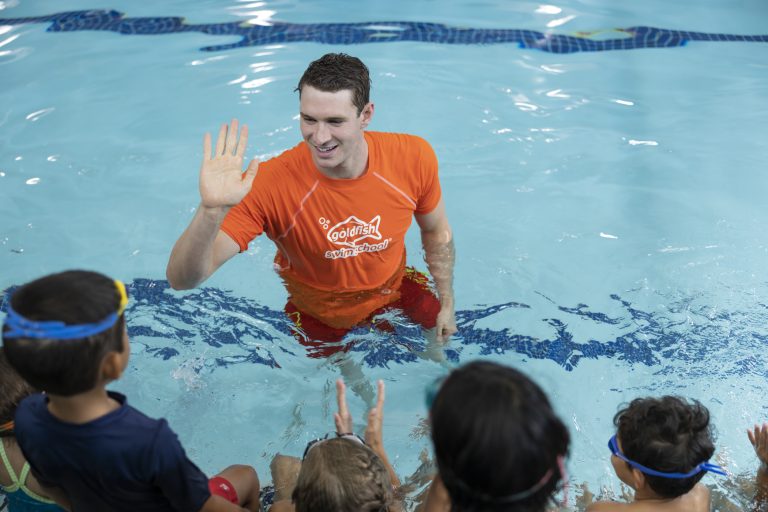 In water image of Goldfish Swim School Ryan Murphy giving high five