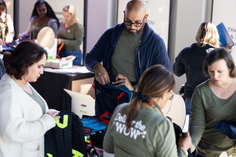 Image of teachers packing backpacks for charity.