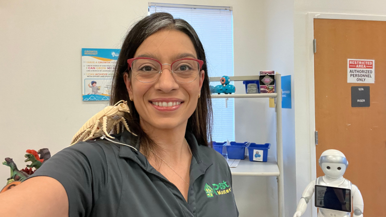 Entomologist standing with robot and bug example